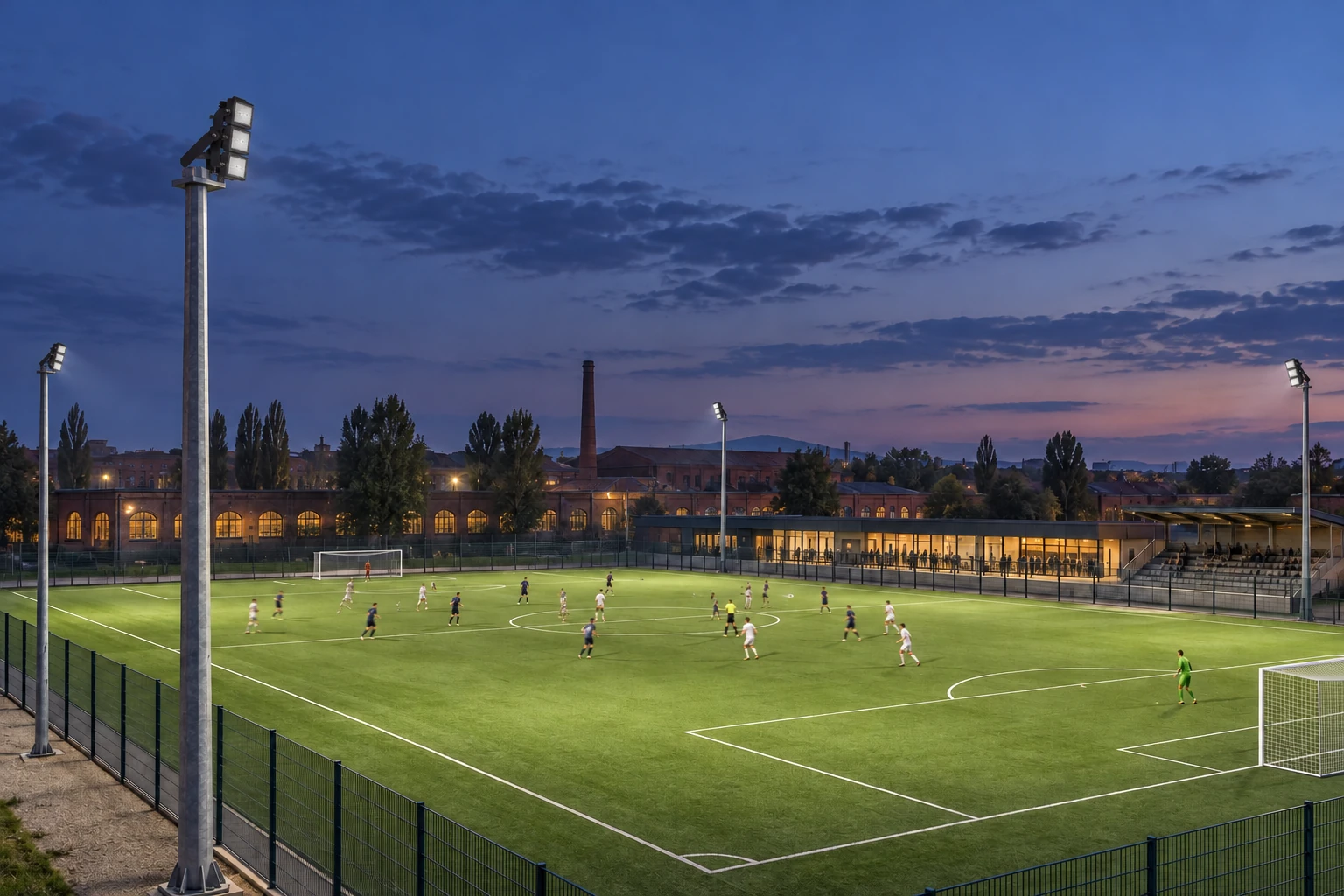 Evening concept with three stacked black modules on a bracket, aimed towards the pitch. The scene identifies no power, optic, tower height or illuminance levels.