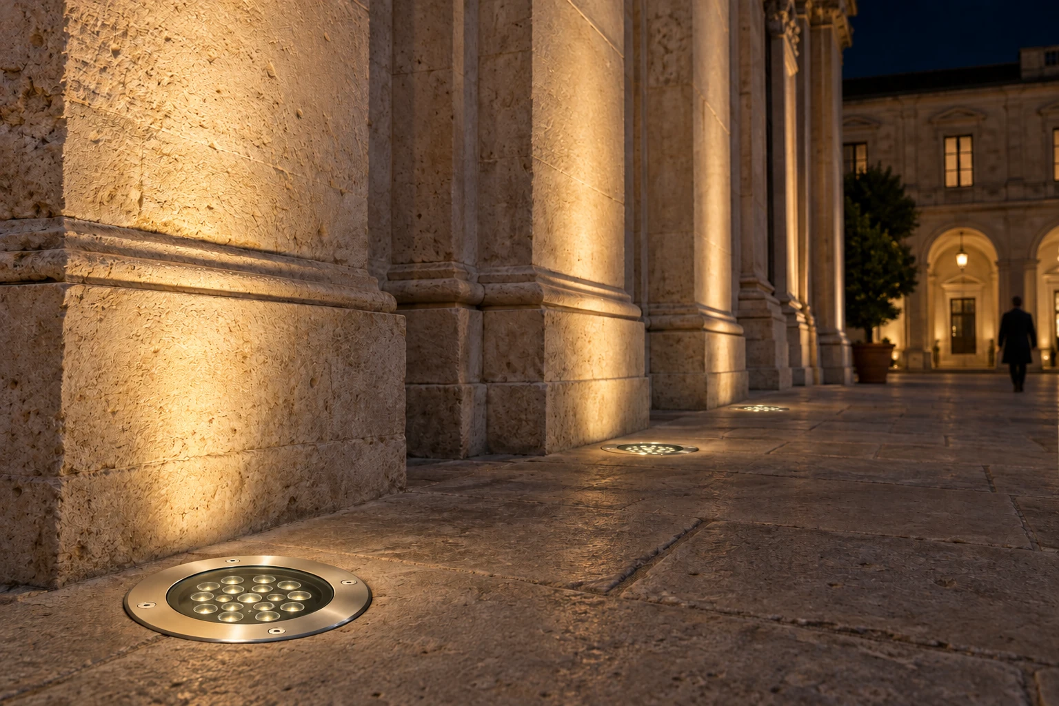 Night concept with ground-flush fixtures, a four-screw rim and eighteen optics. Light is directed towards the facade; the scene identifies no power, diameter or current series code.